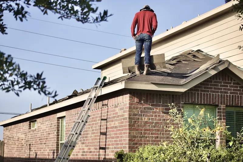 Professional roofer working on a residential roof in De Pere